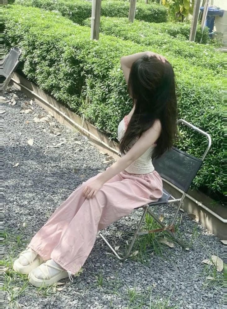 gai xinh che mat tao dang ben goc cay